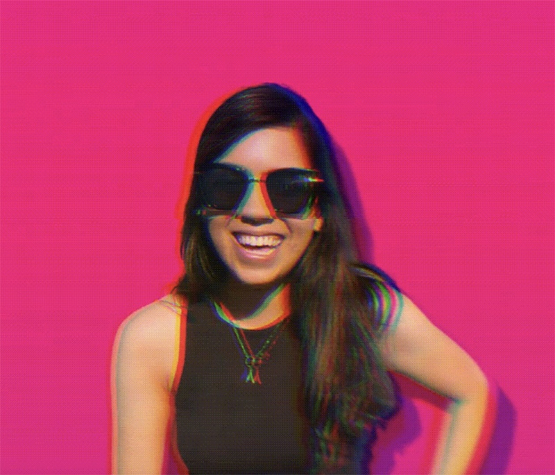 A beaming young lady wearing sunglasses against a fuschia background, with digital distortion effects