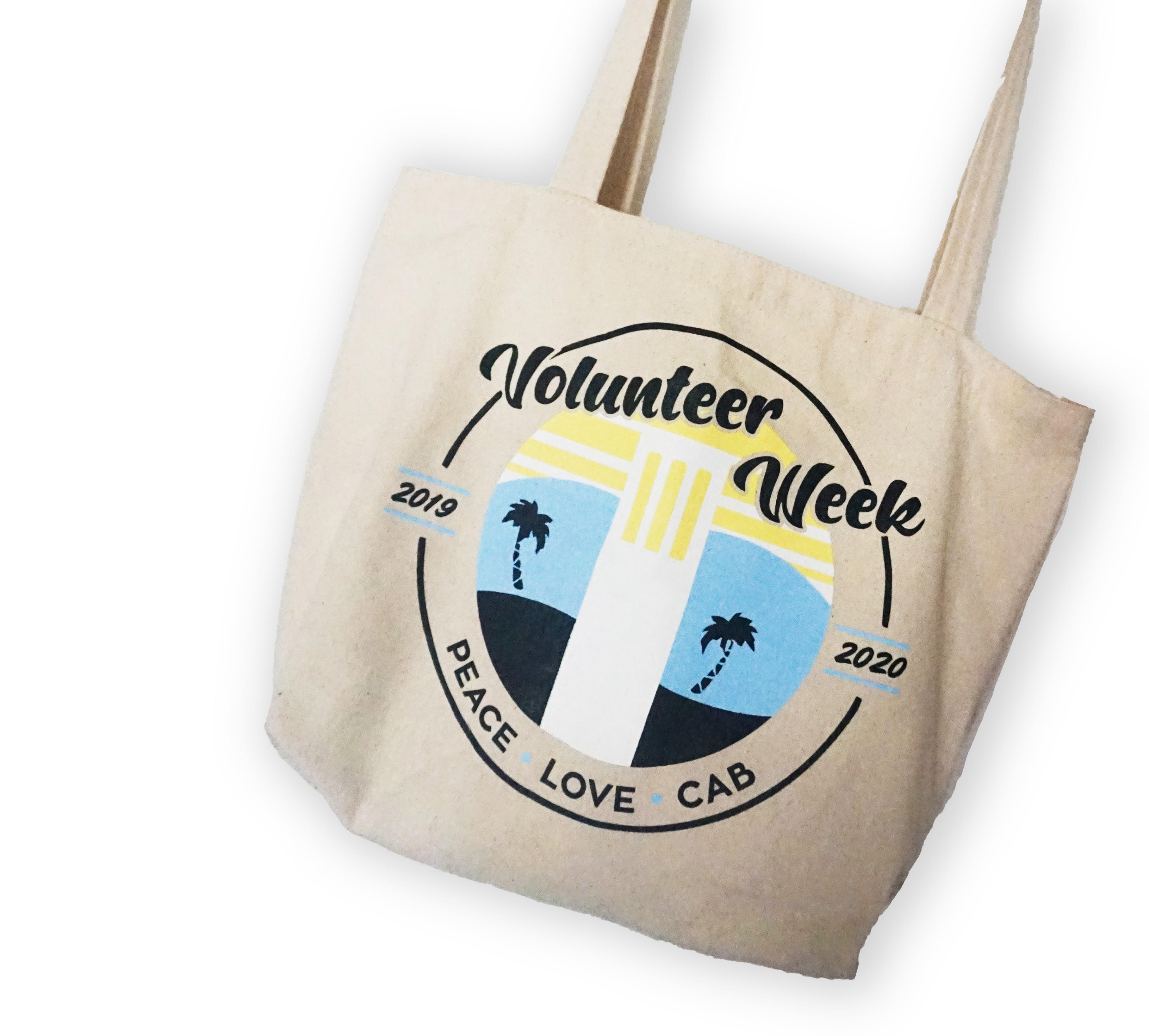 A cream colored tote bag with a graphic of Storke Tower and palm trees, with 'Volunteer Week' printed across the top